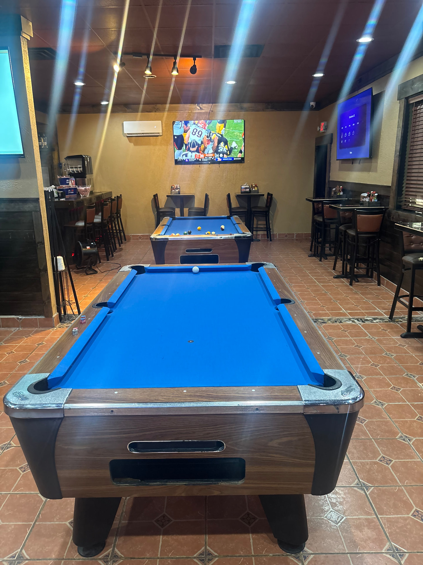 Second view of Pikantes 2 pool tables with football on the TVs and beer tower at the bar