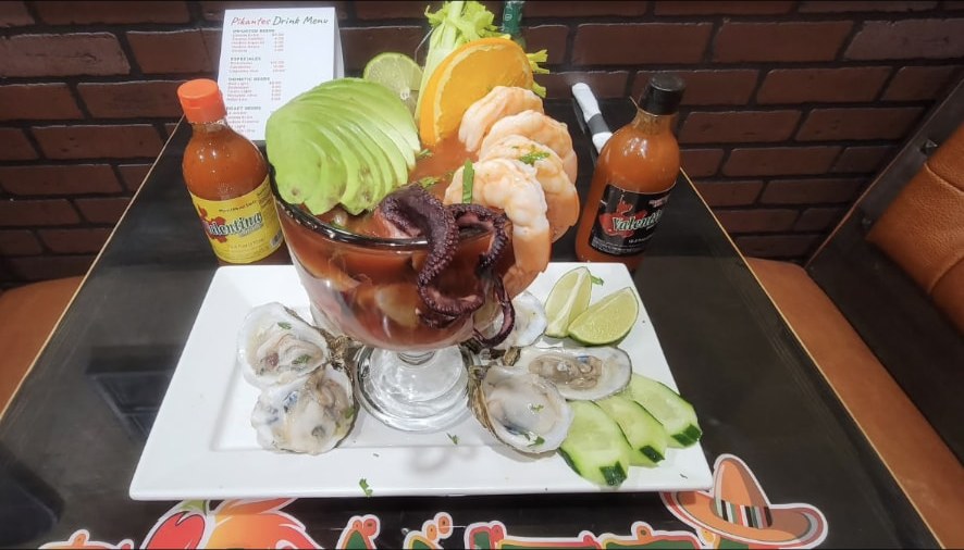 Seafood cocktail with shrimp, octopus and avocado served with raw oysters
