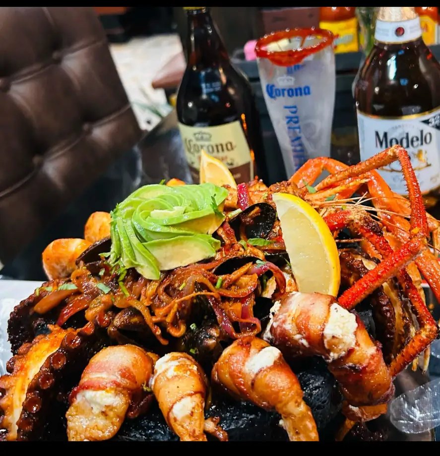 Grilled octopus and bacon-wrapped shrimp piled high with avocado and crab legs